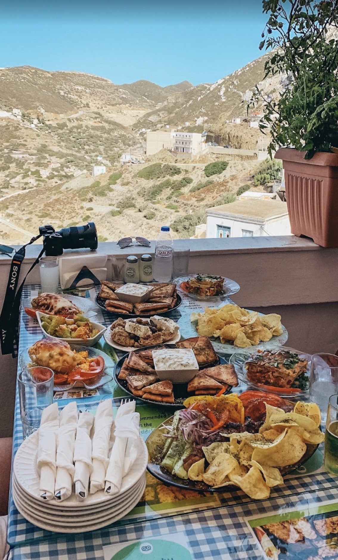 A table of traditional Karpathian food on a terrace overlooking the mountains of Olympos